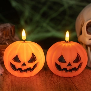 Detail of two Halloween pumpkin LED candle lights with warm glowing Jack-o'-lantern faces