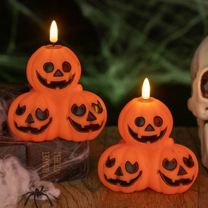 Three-tier glowing Halloween pumpkin lantern with spooky faces on a rustic wooden table