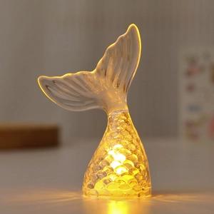 Detail view of glowing mermaid tail lamp with warm LED light and crystal scales texture