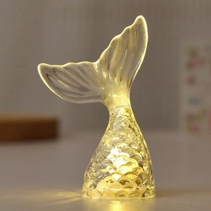Close-up of a mermaid tail LED night light with warm glow and textured scale patterns