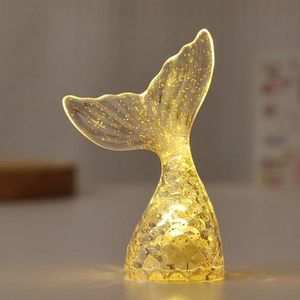 Close-up of a mermaid tail night light with golden sequins and warm LED glow