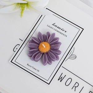 Top view of a purple daisy scented candle with clear petal texture and brand display card