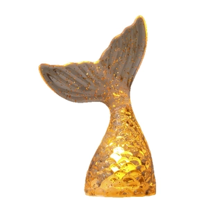 Mermaid tail night light with warm amber glow and golden glitter on white background