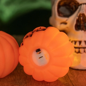 Detail view of the LED switch and battery compartment on an orange Halloween pumpkin lamp