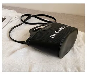 Detalle del bolso de cubo negro en cuero y textura trenzada con bordado BLONMAY