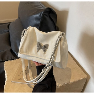 Detail of off-white butterfly buckle on marble textured envelope shoulder bag with chain