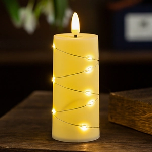 Close-up of ivory LED candle with starry string lights and a flickering flame effect