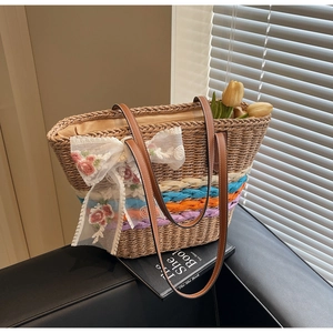 Detailed shot of straw tote bag with floral lace bow and colorful striped base