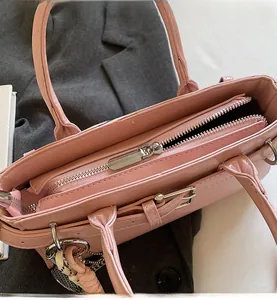 Primer plano de la cremallera de metal plateado y textura de cuero de un bolso rosa