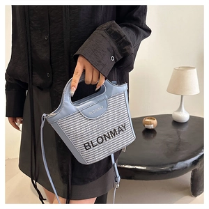 Detalle del bolso tipo cubo trenzado azul claro con detalles de cuero y logotipo BLONMAY
