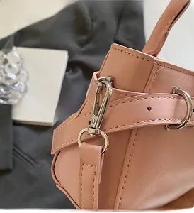 Vista detallada del bolso de cuero rosa con ganchos metálicos plateados de calidad