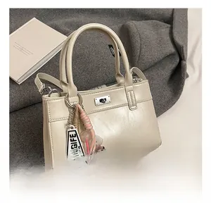 Détails du sac à main en cuir beige avec fermoir rotatif métallique et poignée élégante