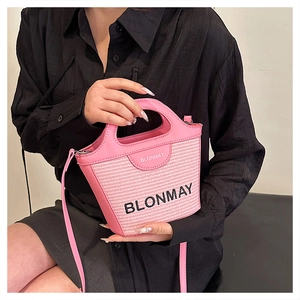 Detalle de bolso de paja rosa con textura tejida y asa de cuero para mujer