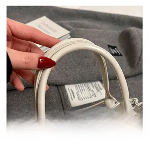 Détail d'un sac cabas en cuir beige avec fermoir en métal argenté et coutures de précision