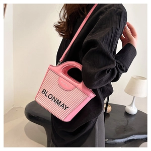 Detalle del bolso tipo cubo tejido rosa con el logo BLONMAY y textura trenzada
