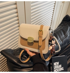 Detail of color-block leather bag with gold lock and pearl charm decoration