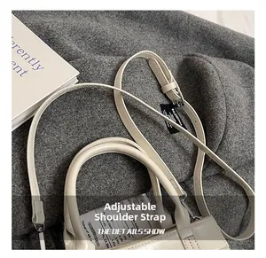 Détail de la bandoulière réglable en cuir et de la texture du sac cabas couleur crème