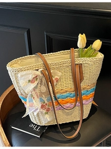 Handwoven straw tote bag with colorful stripes and lace floral bow for beach vacation