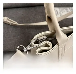 Détails du crochet en métal argenté et de la texture du cuir sur ce sac cabas beige chic