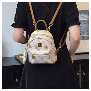 Detail of beige faux leather mini backpack with teddy bear print and golden metal logo