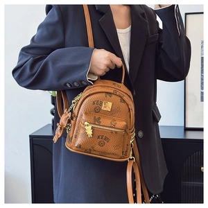 Detail of mini brown backpack featuring bear print and textured synthetic leather