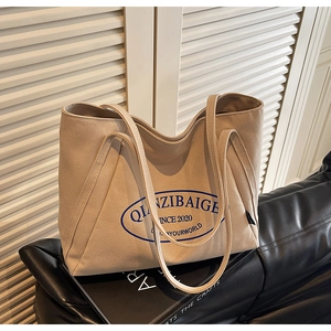 Detalle del estampado azul en el bolso tote de lona beige de gran capacidad para mujer