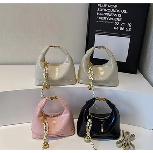 Detail view of four semi-circle luxury handbags with woven charms and gold hardware