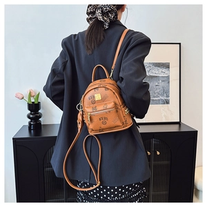 Detailed view of KEBU brown leather backpack worn by a model in a stylish home setting