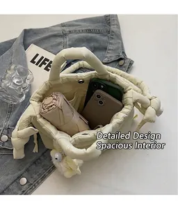 Vista interior del bolso de cubo acolchado beige con cierre magnético y bolsillo con cremallera