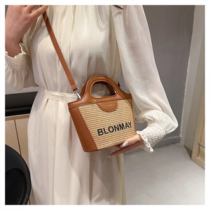 Detalle del mini bolso de paja y cuero marrón de BLONMAY con correa de hombro ajustable