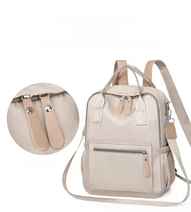 Vue détaillée du sac à dos en nylon beige avec double fermeture et bretelles