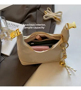Detail view of large capacity off-white crescent bag showing phone and lipstick storage