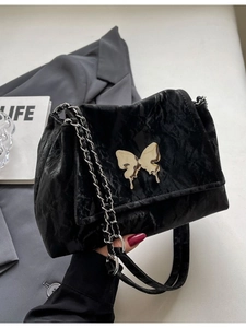 Black tote bag with pleated texture and fluid silver butterfly buckle on chain strap