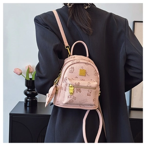 Mini pink bear print backpack styled on a model in a casual business chic outfit