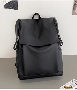 Détail du sac à dos noir à rabat avec fermetures éclair doubles et poches latérales