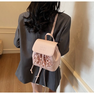 Detail of pink mini PU leather backpack with white pearl accents and drawstring closure