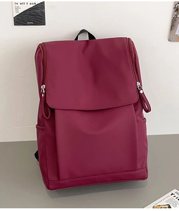 Détail du sac à dos en nylon bordeaux avec fermeture à rabat et poche latérale utile