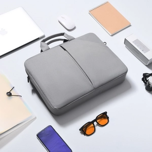 Sacoche ordinateur grise en tissu résistant avec accessoires de bureau et gadgets