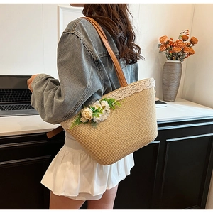 Detail of woven straw tote with white lace trim and floral accents for beach vacations