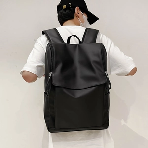 Vue arrière d'un sac à dos minimaliste en nylon noir étanche sur mannequin avec rabat et poches