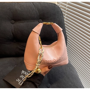 Pink semi-circle dumpling bag detail with knot handle and golden bell charm
