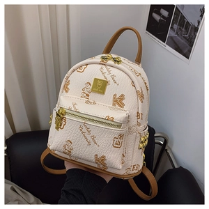 Close-up of teddy bear university print and gold bear-shaped zipper on mini backpack