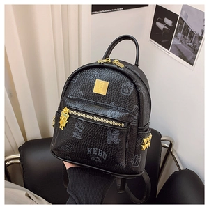 Close-up of black leather backpack featuring gold bear logo and pyramid stud side details