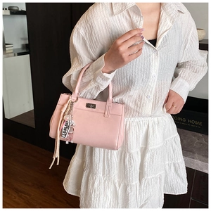 Détail du sac à main rose avec pompon élégant et charmant pendentif en forme d'ours