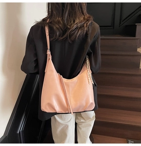 Detail of pink large hobo bag with fringe and adjustable strap on a model