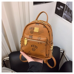 Detail of mini brown faux leather backpack with bear prints and a metal bear zipper pull
