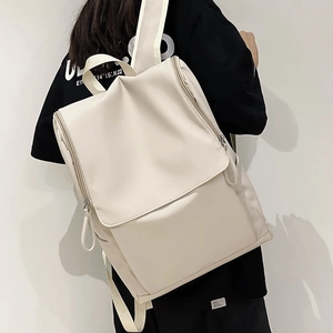 Détail du sac à dos d'ordinateur beige imperméable avec rabat et fermetures éclair en métal