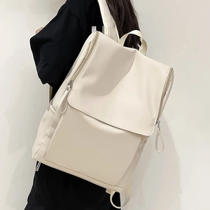 Vue latérale d'un sac à dos blanc crème montrant sa grande capacité et son rabat moderne