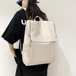 Vue détaillée d'un sac à dos crème minimaliste avec rabat et fermetures éclair latérales