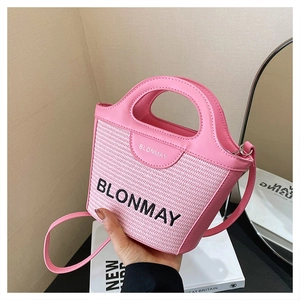 Detalle de mini bolso bombonera de cuero trenzado rosa con logo BLONMAY y bandolera